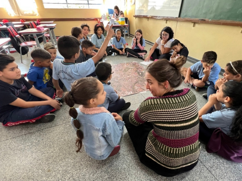 Crianças em roda observam o mapa de Santo André com as educadoras
